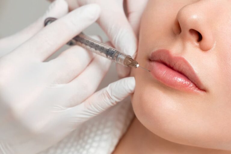 Woman receiving lip filler injection by practitioner in white gloves, demonstrating professional lip enhancement procedure that requires proper aftercare protocols for optimal healing and results