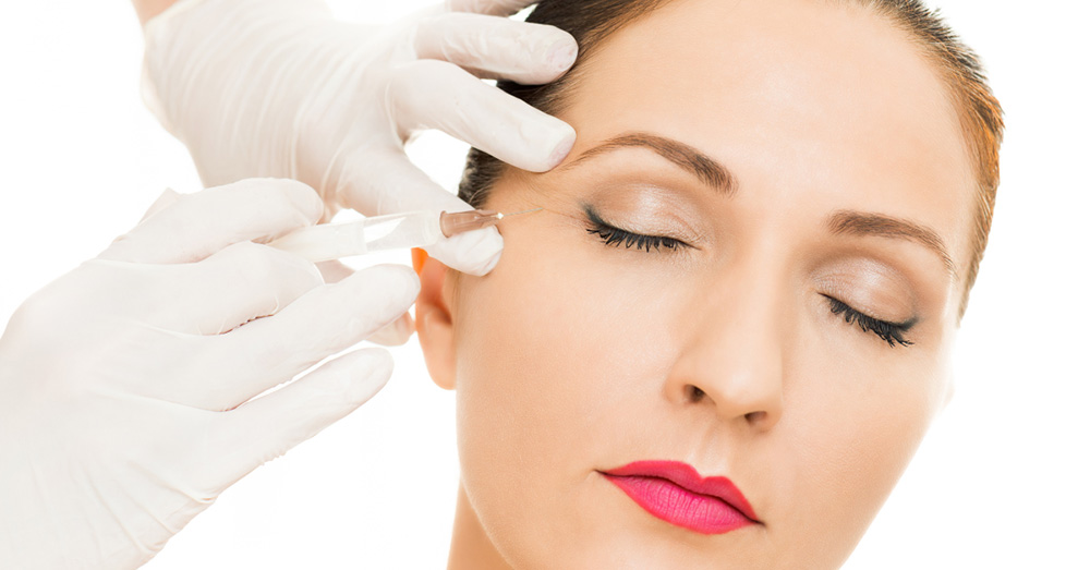 A close-up portrait of a woman receiving aesthetic treatment