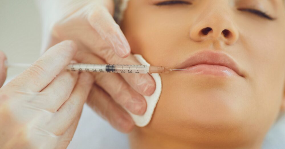 Side view of a woman's face during a lip filler injection