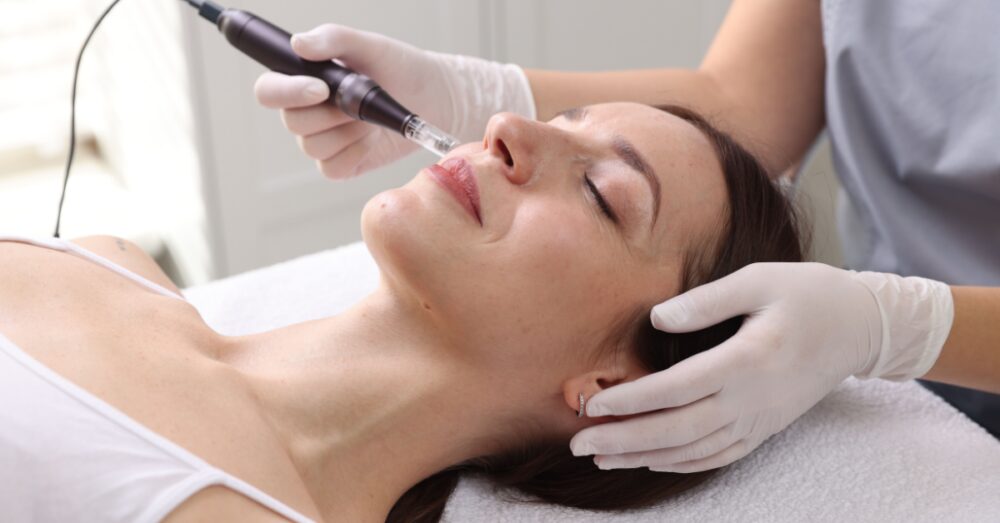 Aesthetician performing a microneedling treatment on a woman's face