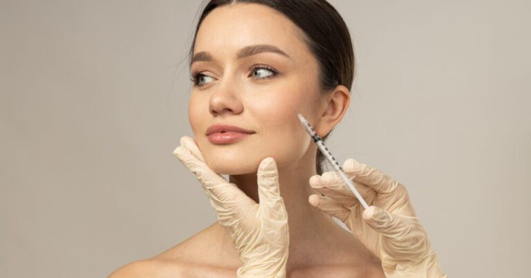 A woman receiving Botox injections near the jawline from a provider wearing white gloves