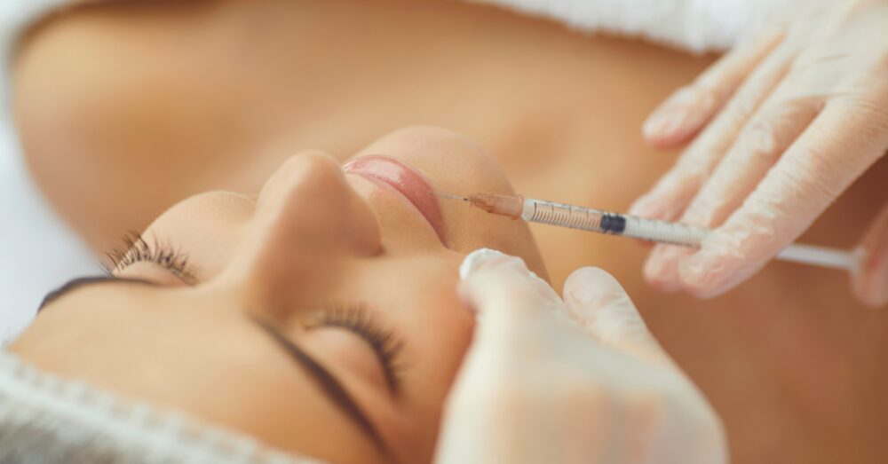 Provider injecting filler into a woman’s lower lip