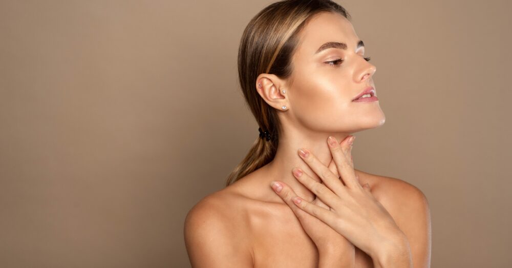 Woman touching her neck while looking to the side