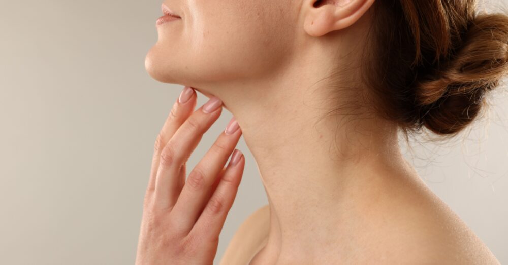A close up of a woman touching her neck