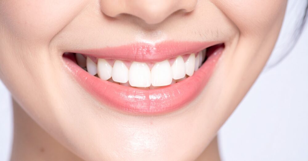A close up of a woman smiling against a bright background